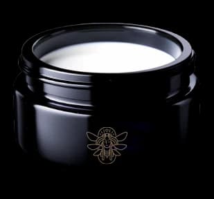 Open midnight blue Mellifera cream jar with a gold emblem